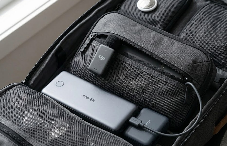 A traveler vlogging with a DJI Mic 2 wireless microphone clipped to their shirt while walking through a busy city market.